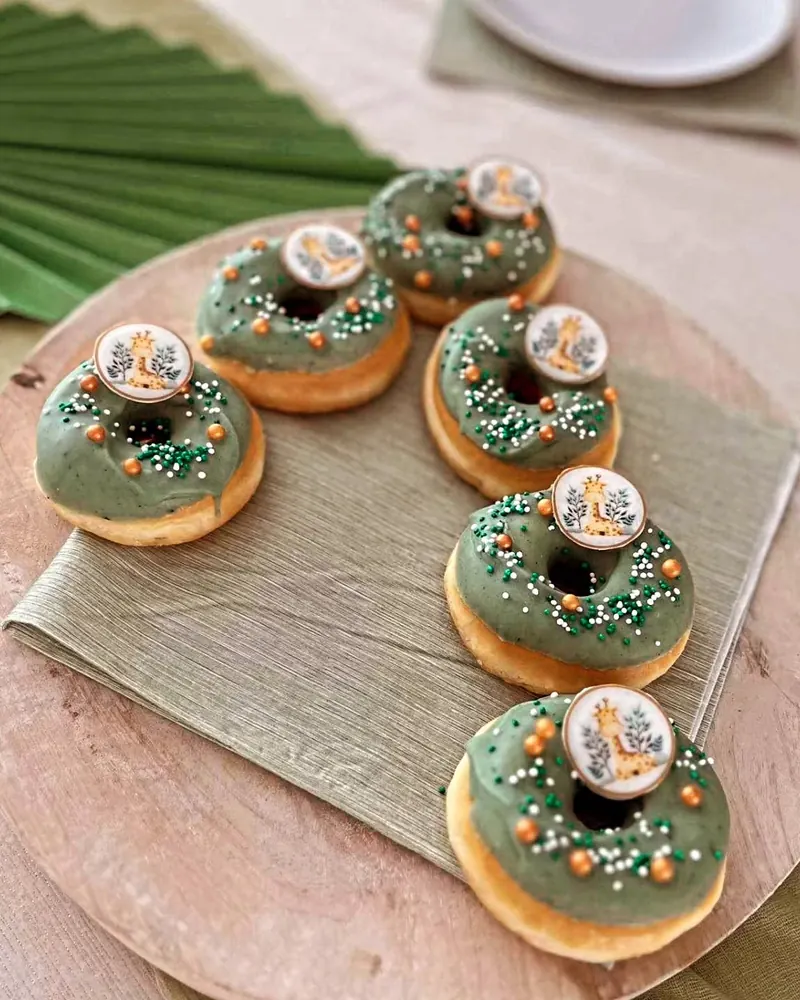 Groen geglazuurde mini-donuts met parelsuiker op een houten plank