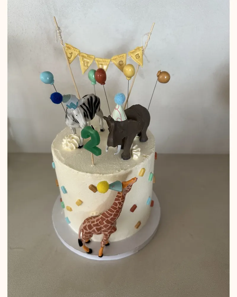 Witte verjaardagstaart met confetti, safaridieren en het cijfer 2